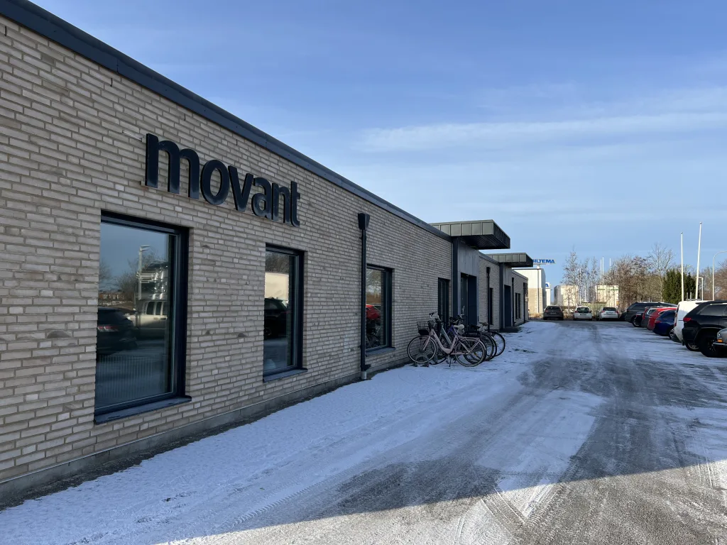 Fasadbild på Movant Varbergs byggnad med cyklar parkerade utanför och snö på marken.