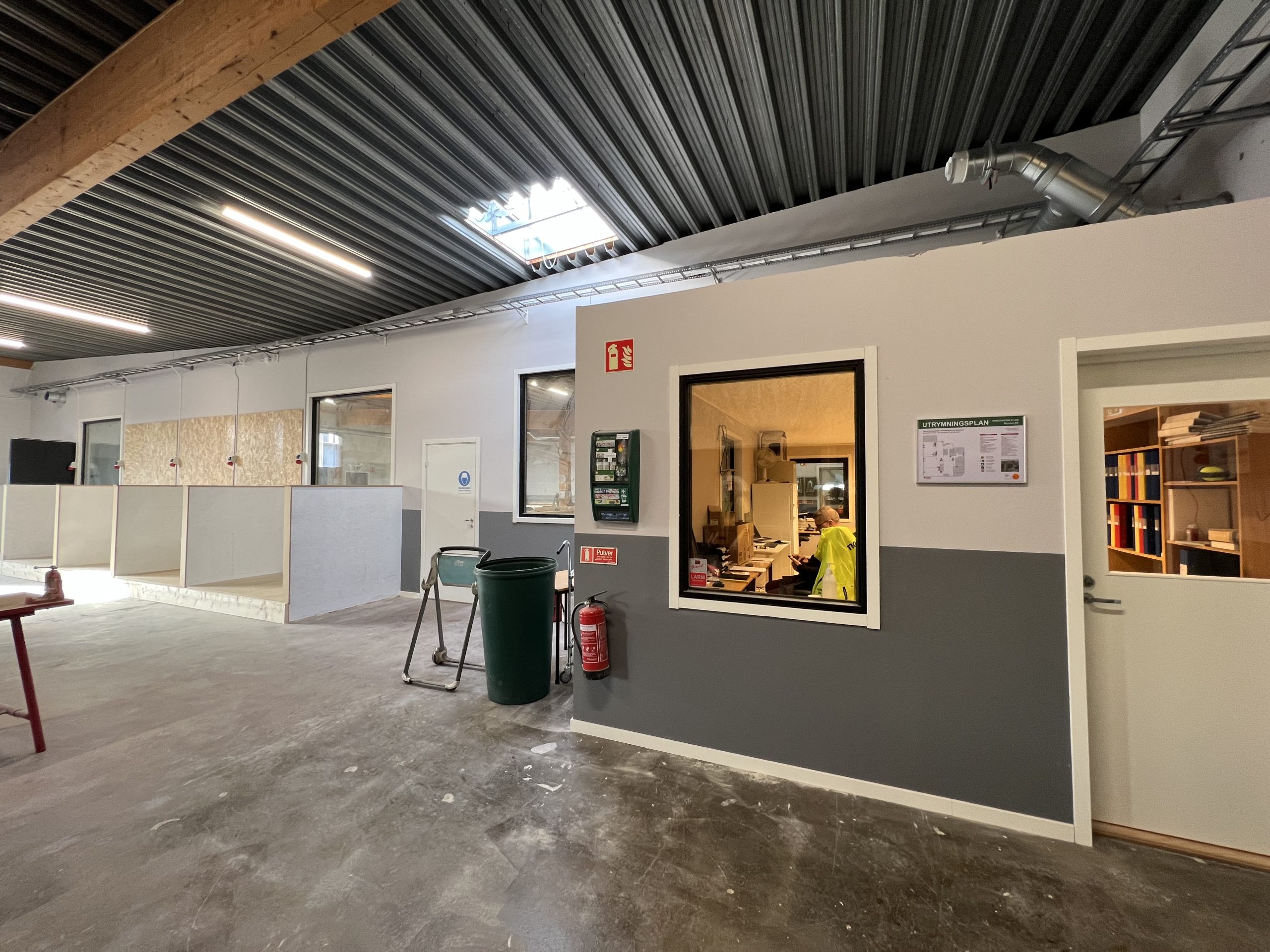 Interiör från Movant Varbergs lokaler med fönster in till kontorsutrymme och verkstad.